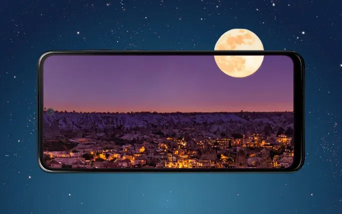 Imagen nocturna panóramica de una ciudad con luna llena de fondo